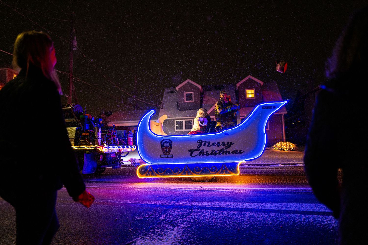 Blue LED-lit holiday boat displays glowing on a dark winter night.