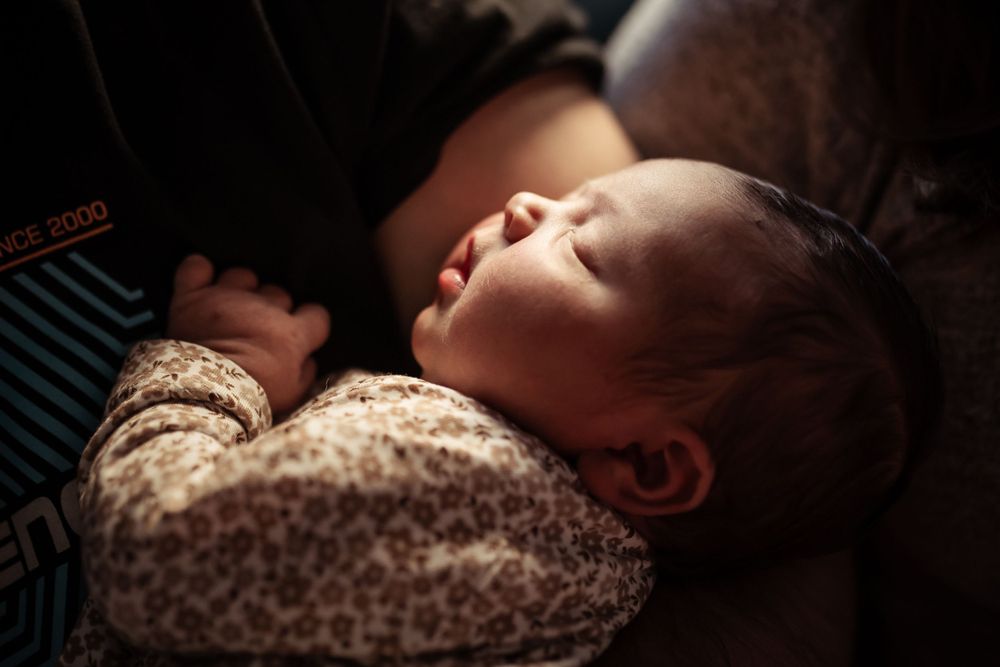Peaceful sleeping scene in low light with floral patterned fabric.