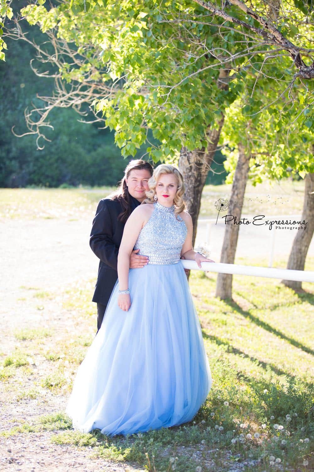 A romantic photoshoot in a park setting featuring a flowing light blue formal dress.