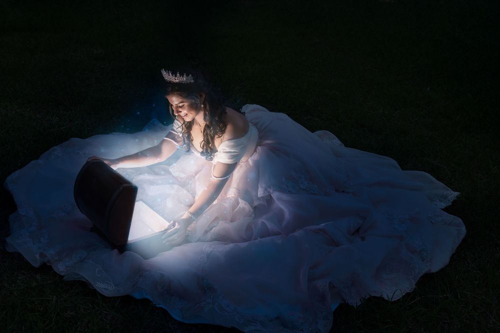 An ethereal nighttime photoshoot featuring a glowing white dress against a dark background.