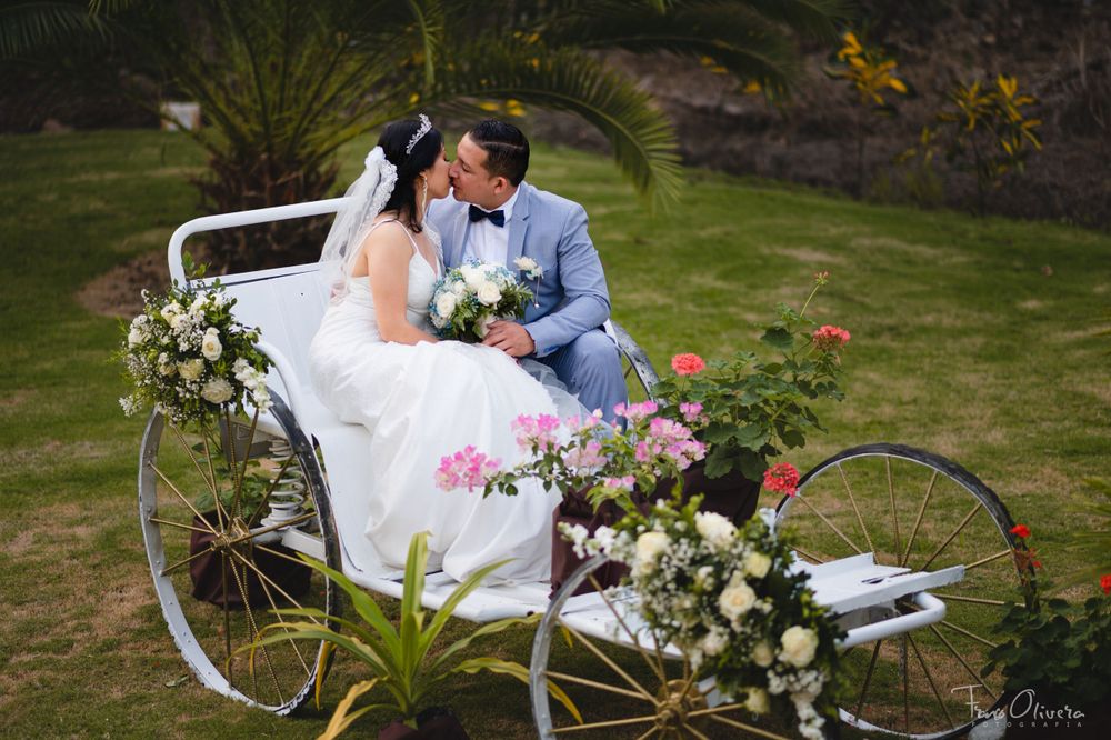 White vintage bench decorated with floral arrangements in a garden setting.