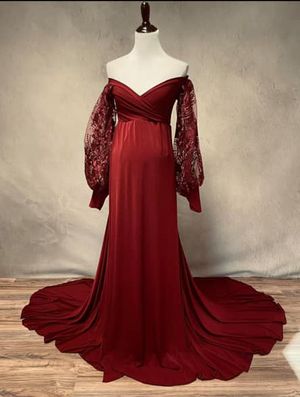 Burgundy velvet maternity gown with lace sleeves and dramatic train on display.