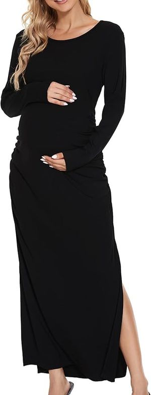 Woman in black maternity dress posing against white background.
