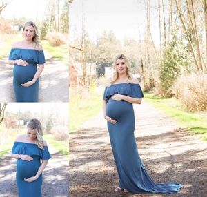 Maternity photo session in a blue dress on a wooded path during golden hour.