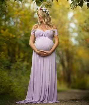 Flowing purple maternity dress captured in golden autumn woodland scene.