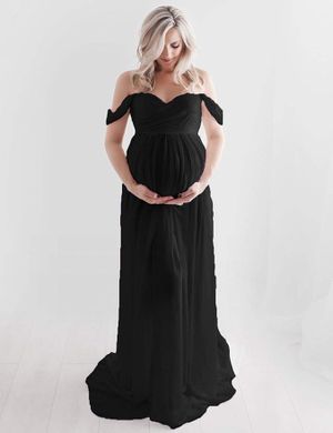 Woman in black off-shoulder maternity gown poses against white background.