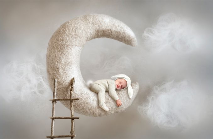 Composite newborn photo of baby sitting on moon