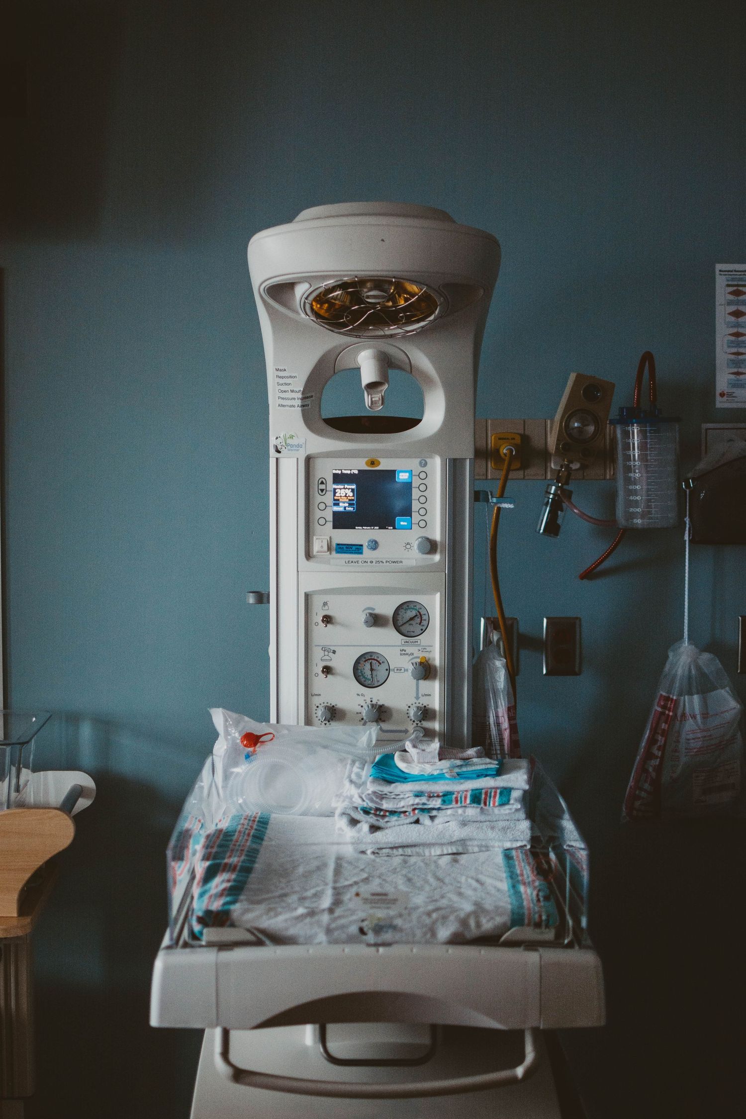 Modern medical equipment station with monitors and supplies in hospital room.