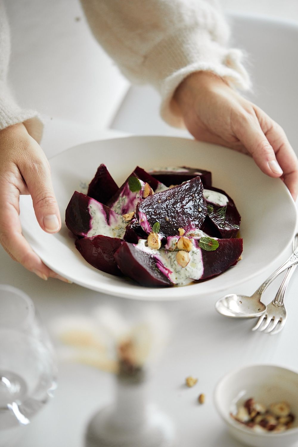 Elegant plating of roasted beets with garnish on white ceramic dish.