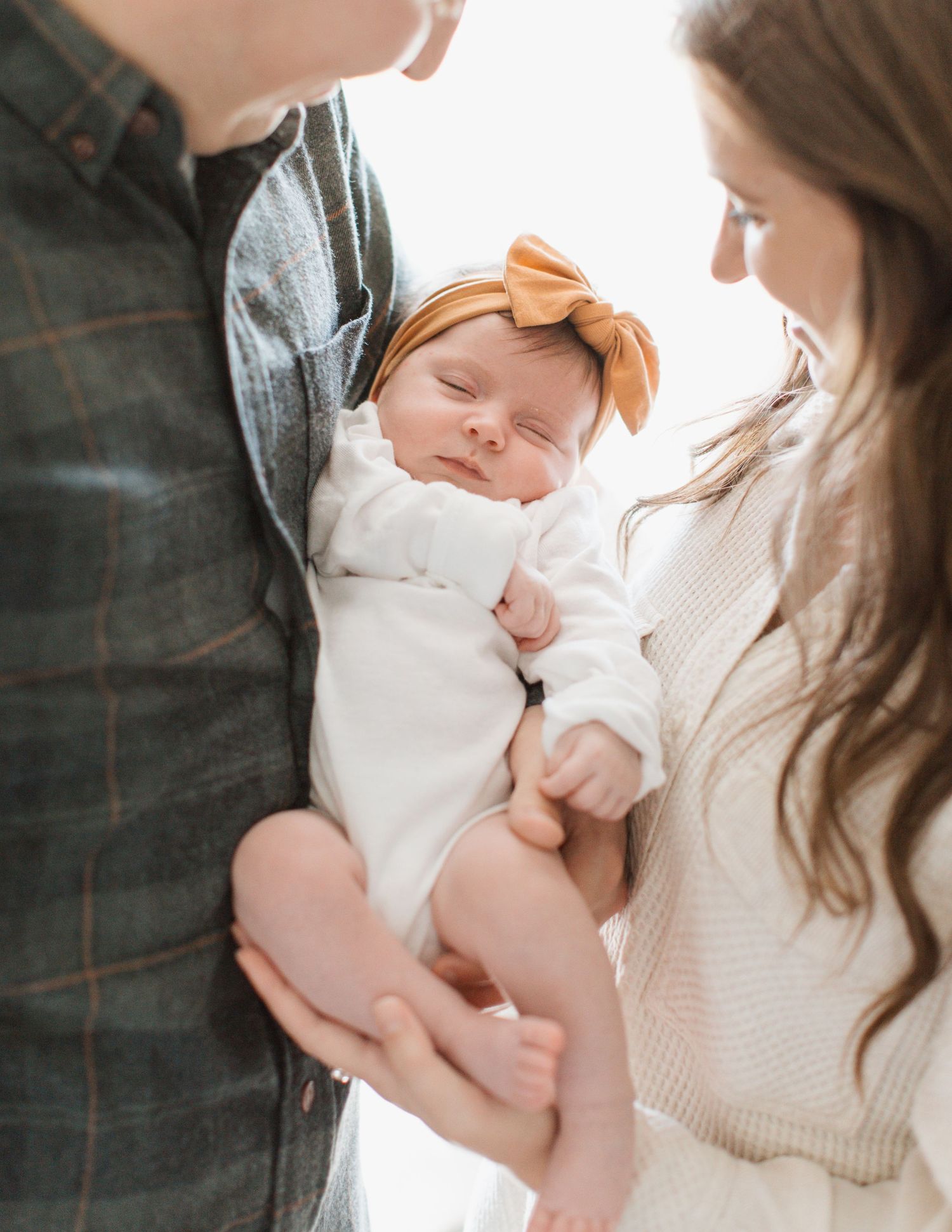 In-home newborn photo snuggled with parents in Davison, MI