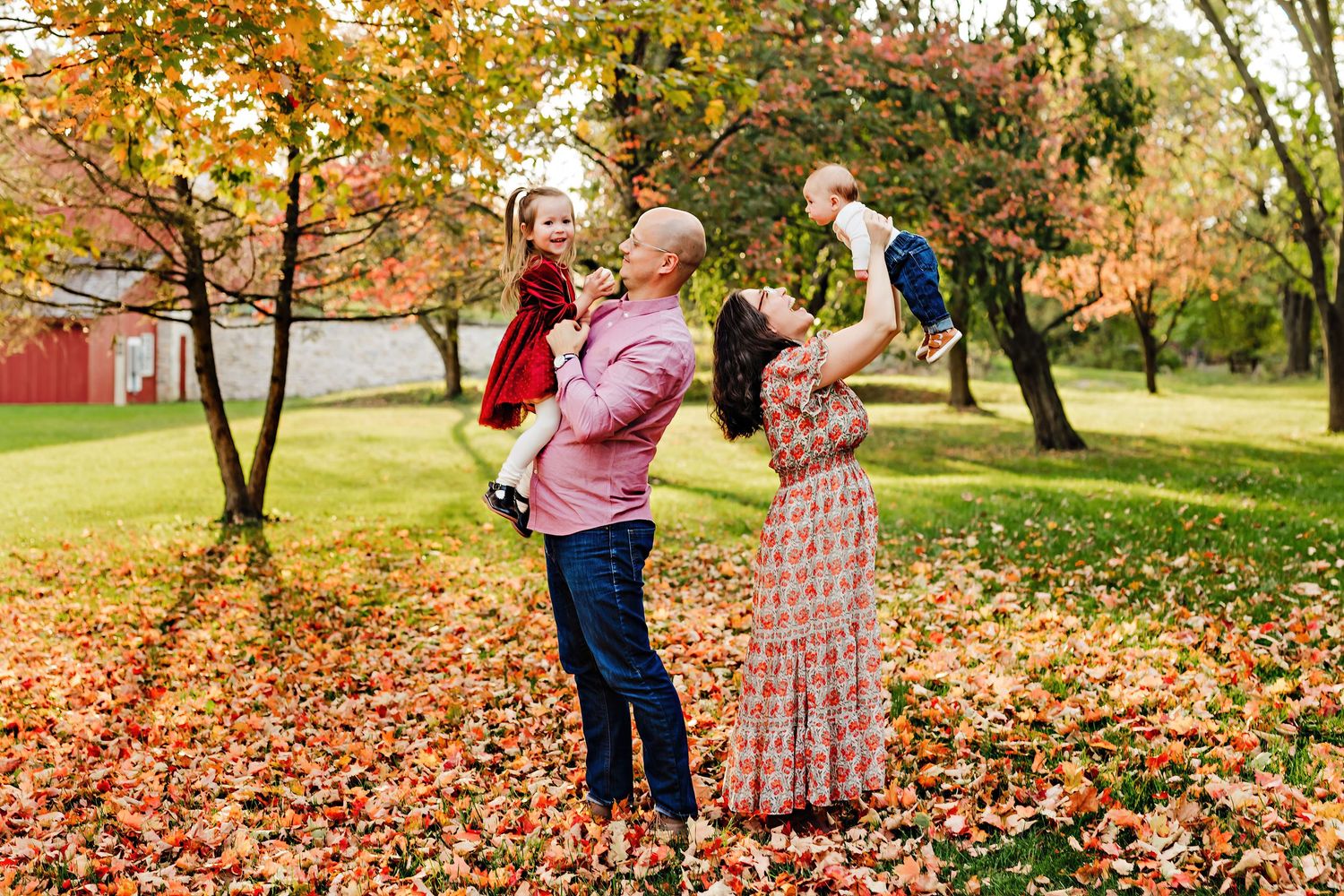 Mother and child share a joyful moment outdoors in golden evening light.