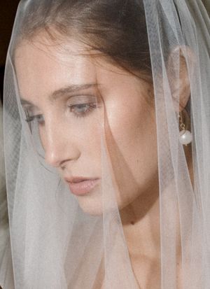 Close-up profile views of bride wearing delicate tulle veil.
