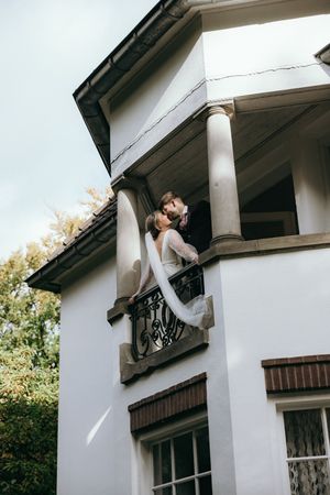Creative architectural wedding photos showing couple posing by white building columns.