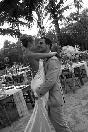 Black and white photos of a romantic first dance at an outdoor wedding reception.