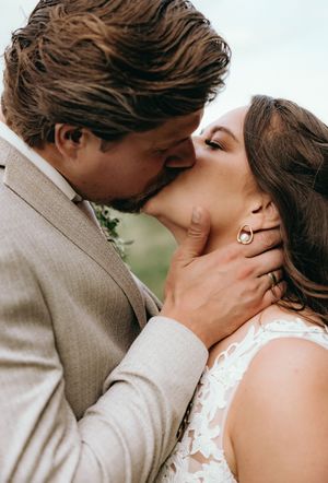 Romantic sequence of wedding day kisses between newlyweds in a gray suit and white dress.