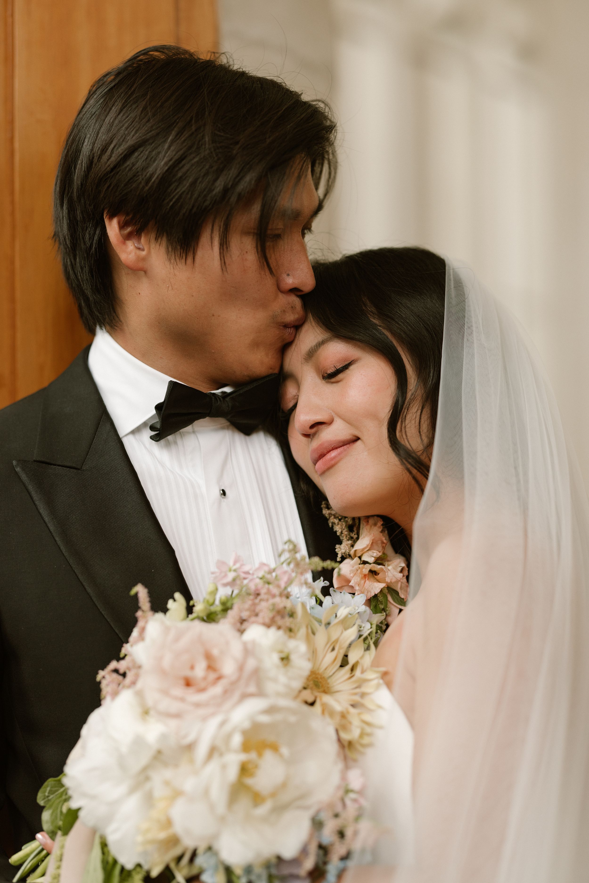 Romantic wedding couple sharing intimate moments in formal attire.