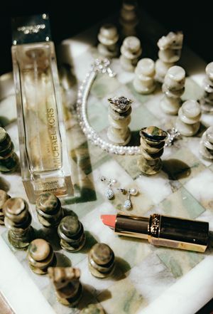 Elegant wedding accessories including perfume bottles, jewelry, and decorative items on white surface.