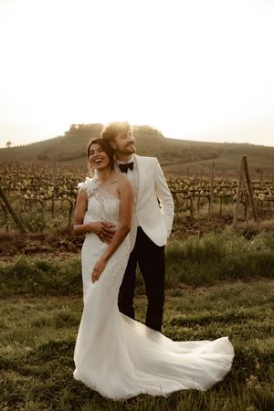 Romantic sunset wedding portraits in a rustic vineyard setting.