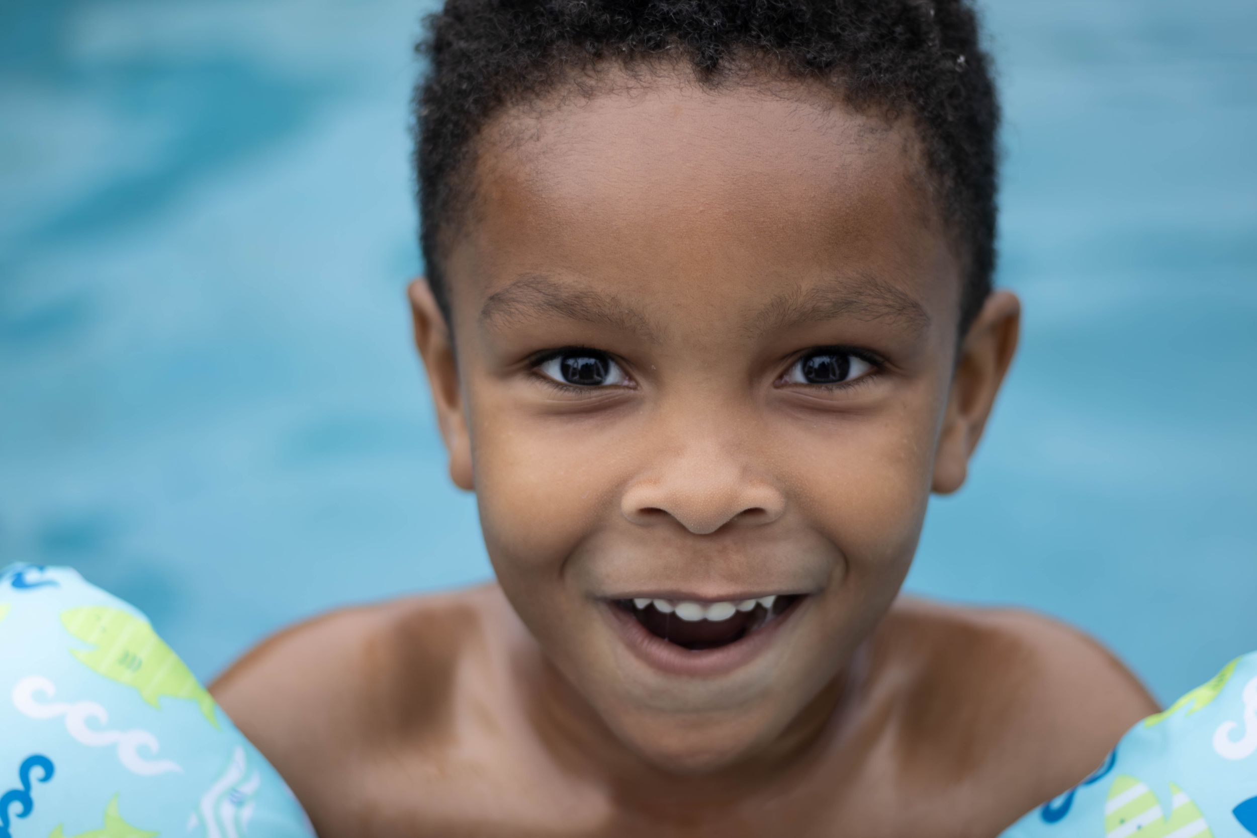 Little Boy smiling for the camera in the pool
