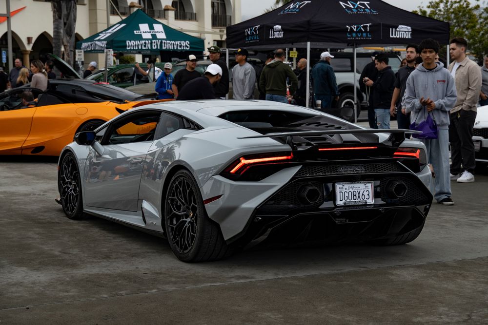 Silver Lamborghini Huracan rear view at an outdoor exotic car meet in California.