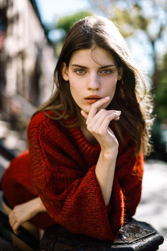 Fashion portrait in red knit sweater with autumn outdoor backdrop.