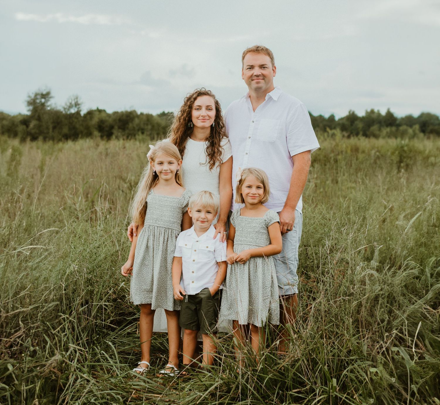 Inman South Carolina Family Photographer. Holston Creek park outdoor family photoshoot. Family of five smiling at photo in field at park.