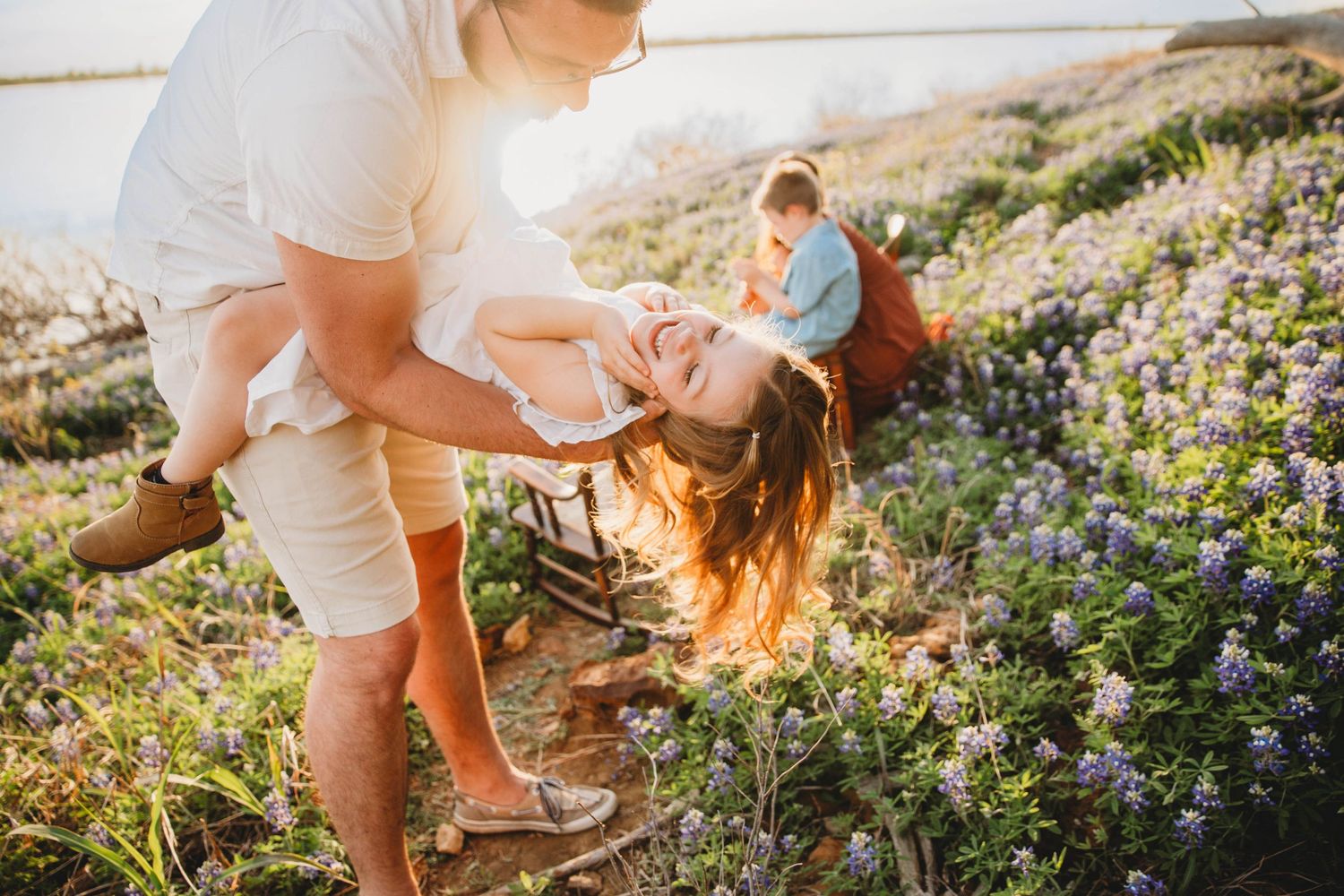 Playful intimate moment captured among purple wildflowers at sunset.
