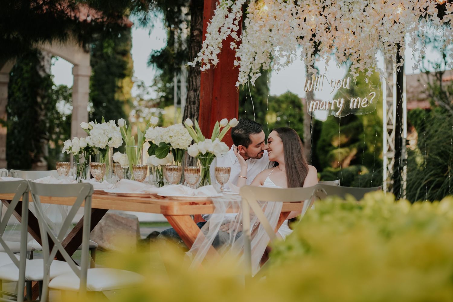 Intimate outdoor dining setup with string lights and floral arrangements.