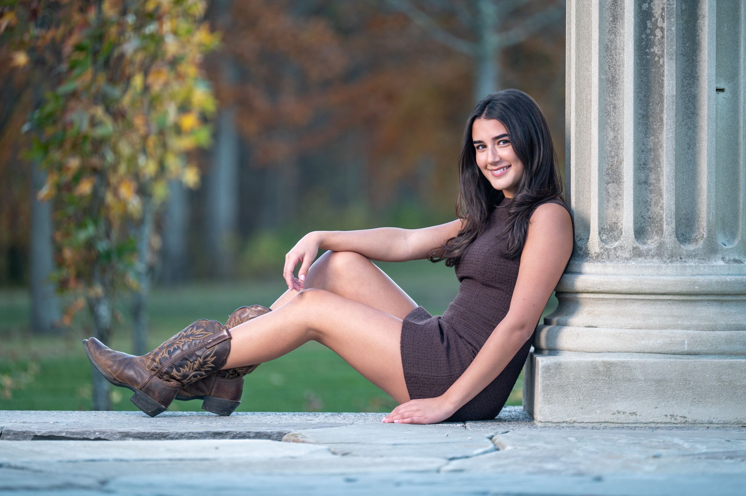 A series of artistic outdoor portrait photos showing someone posing near white stone columns in a garden setting.