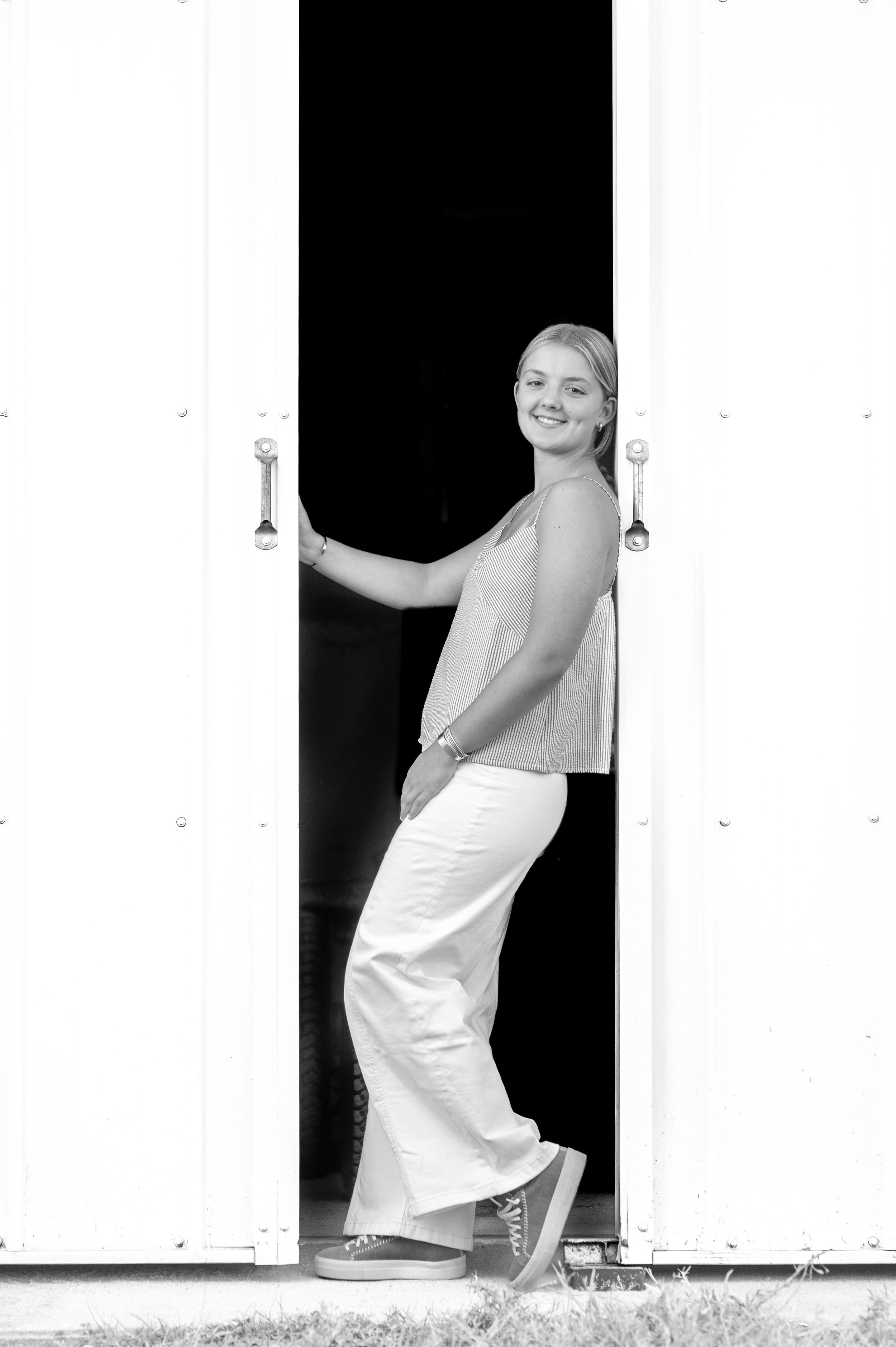 A series of black and white photos showing a person in white clothing posing against a white wall.