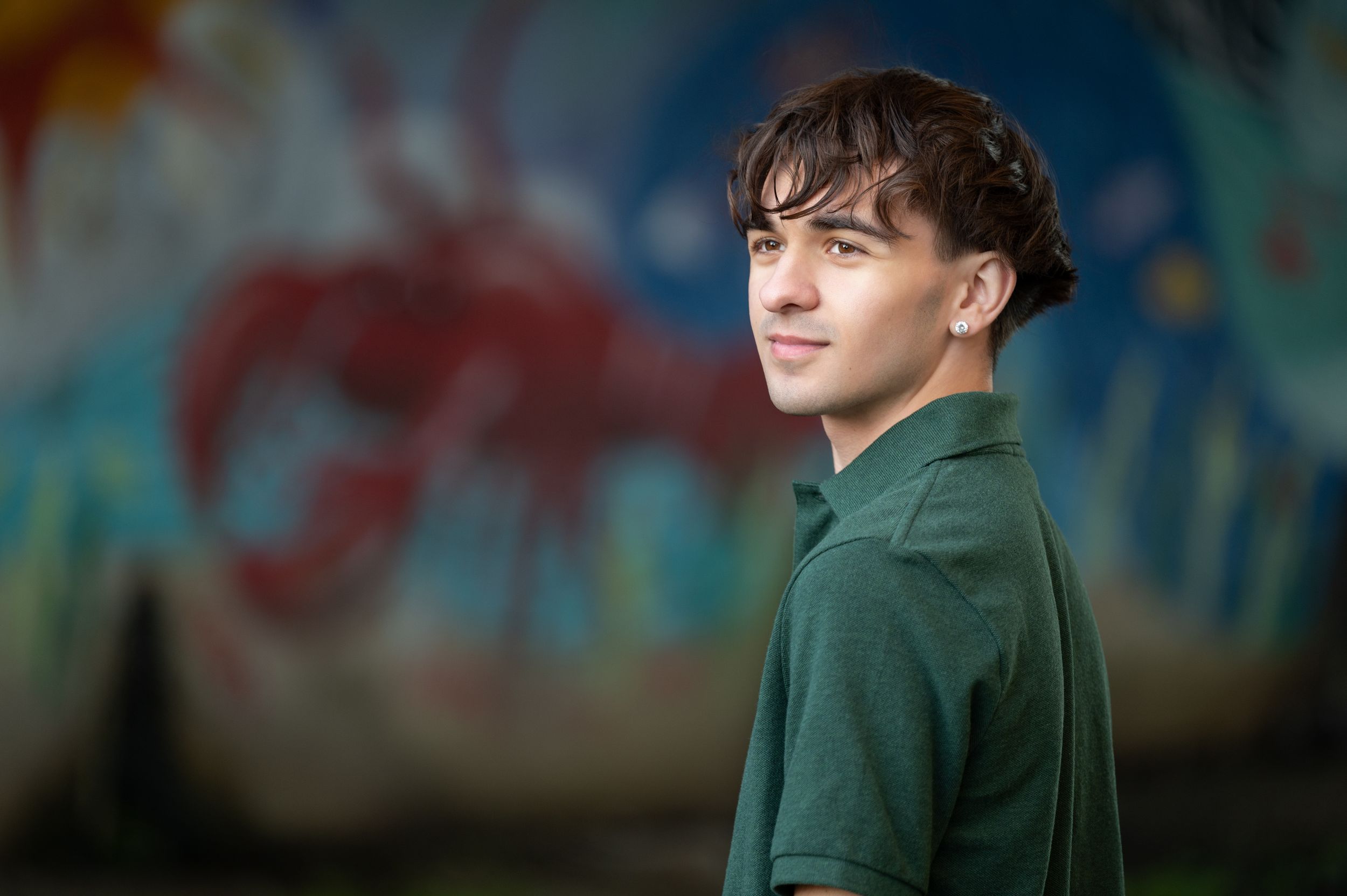 A person wearing a dark green jacket poses against a blurred background in a series of similar shots.