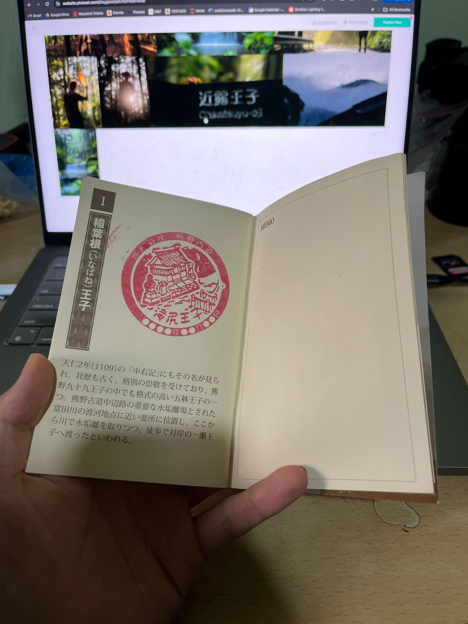 An open book displays Japanese text and a red circular stamp or seal.