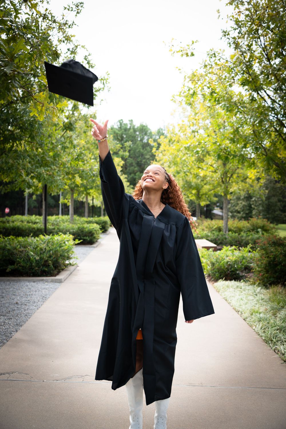 Series of joyful graduation photos showing celebration poses outdoors on a tree-lined path.