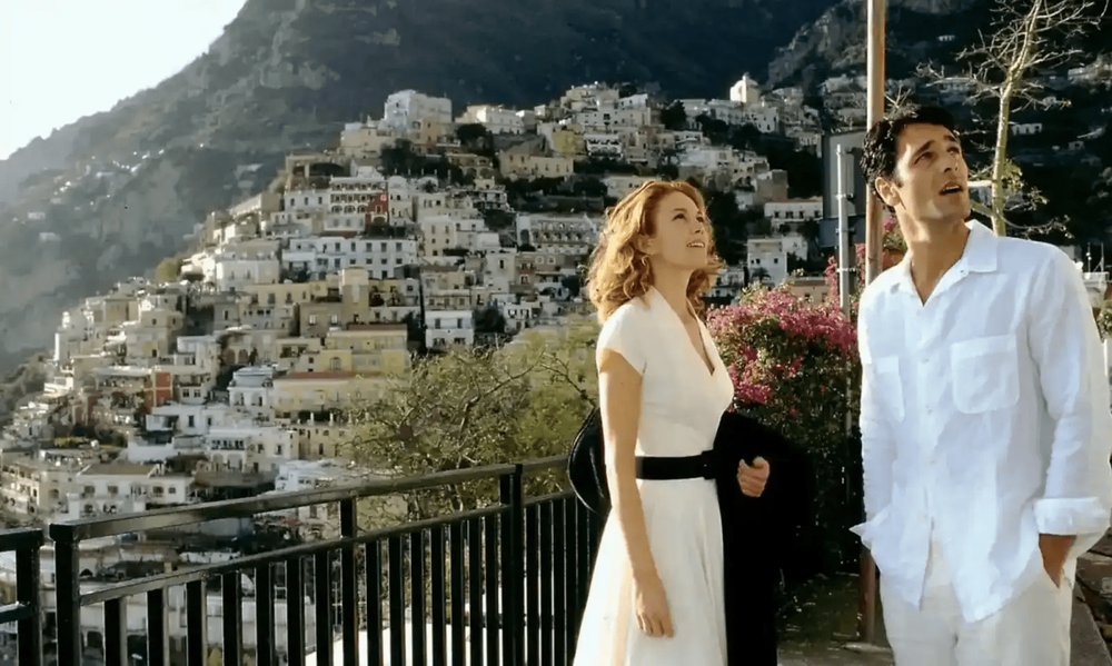 A scenic Mediterranean coastal town view with white buildings cascading down hillsides.