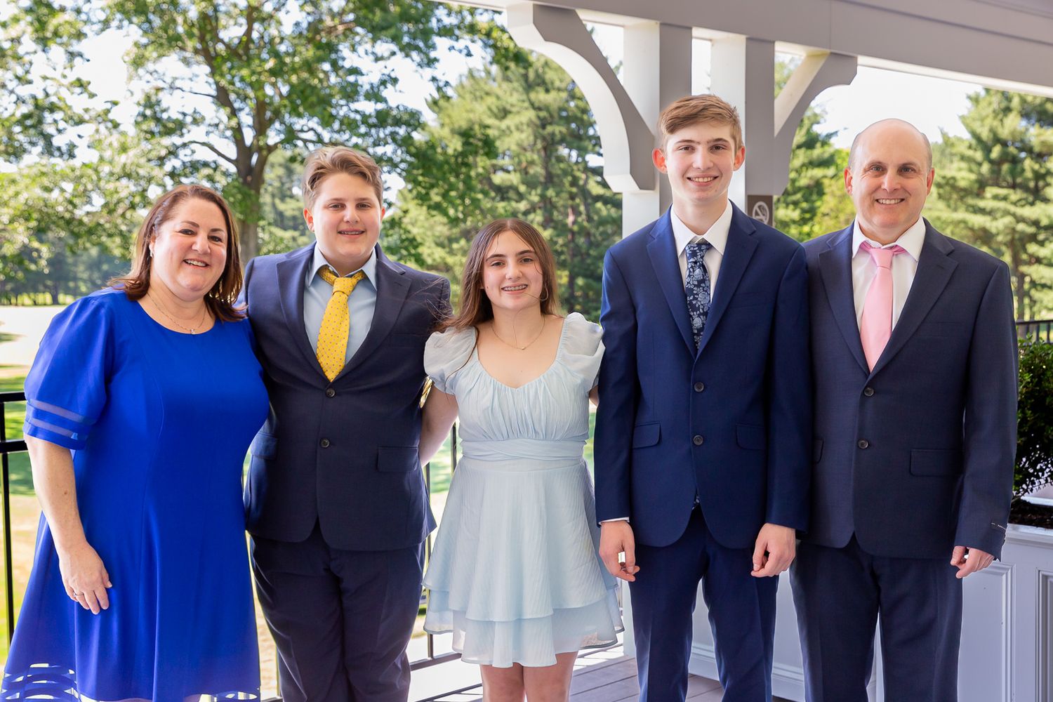 Formal group photo of family members under white gazebo.