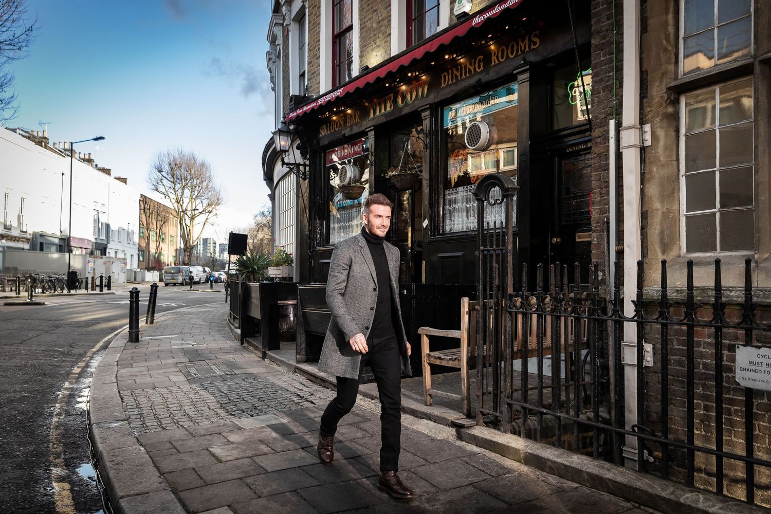 Street scene outside traditional British pub with curved architecture.