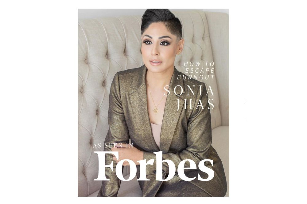A Forbes magazine cover with professional styling and lighting against a tufted beige backdrop.
