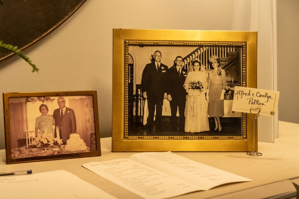 Vintage family photographs displayed in wooden frames on a desk.