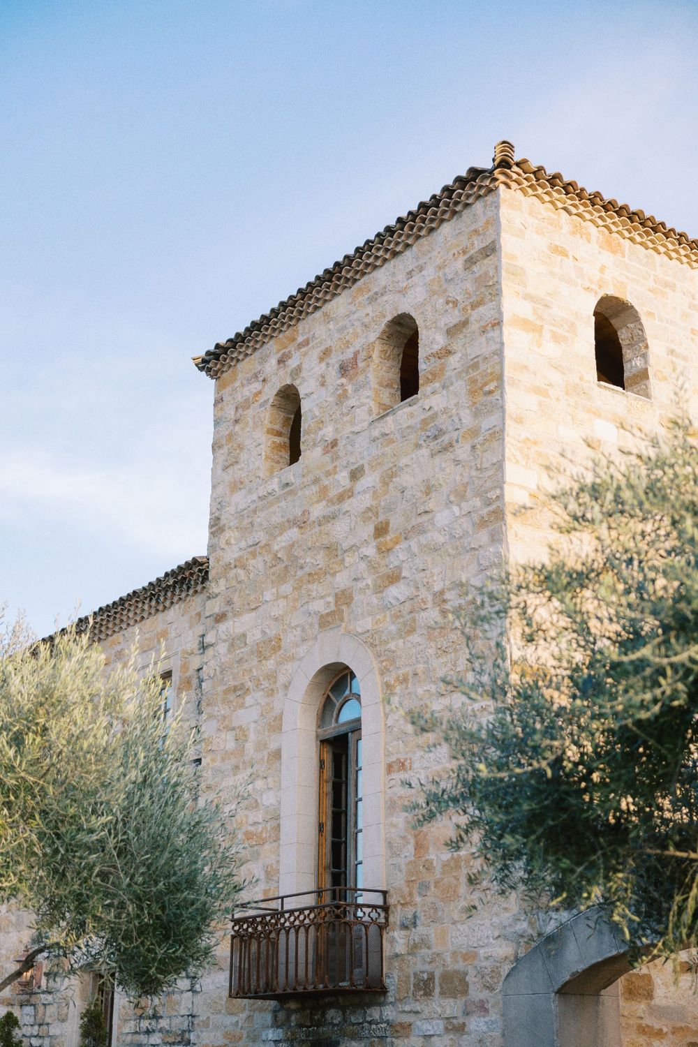 Historic stone tower venue under a clear blue sky, fine art architectural wedding photography.