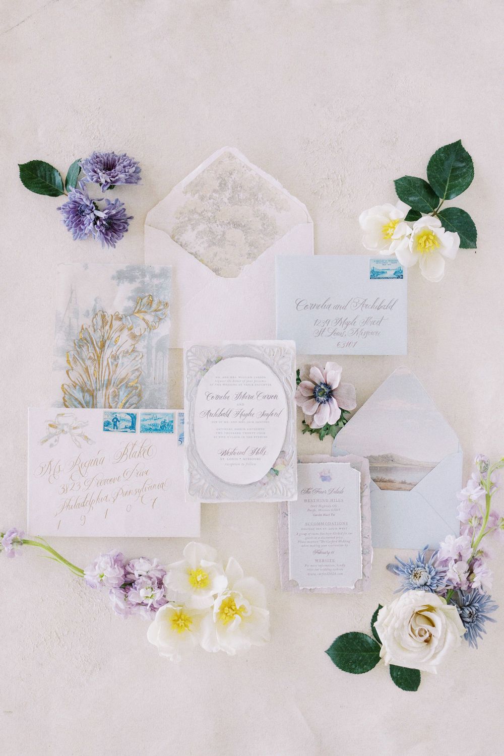 Detailed flat lay arrangement of an elegant wedding invitation suite with matching floral accents.