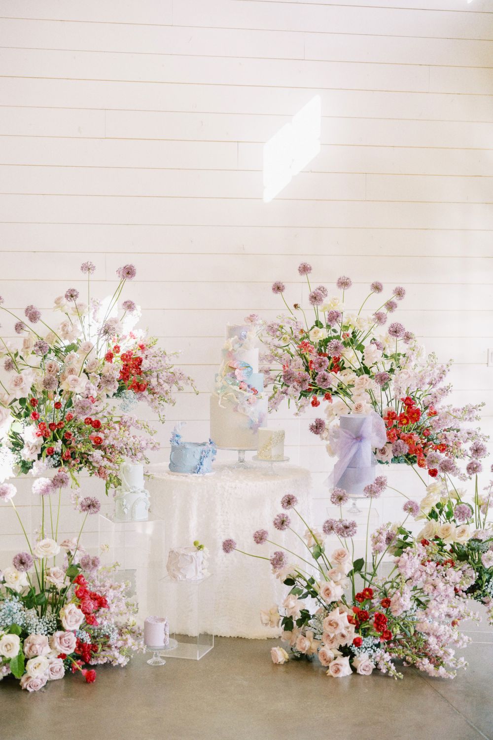 Elegantly set wedding reception table with abundant colorful floral centerpieces and runners.