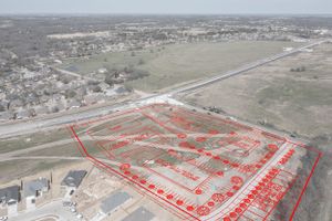 Aerial view of development land with red boundary lines marking property divisions and planning zones.