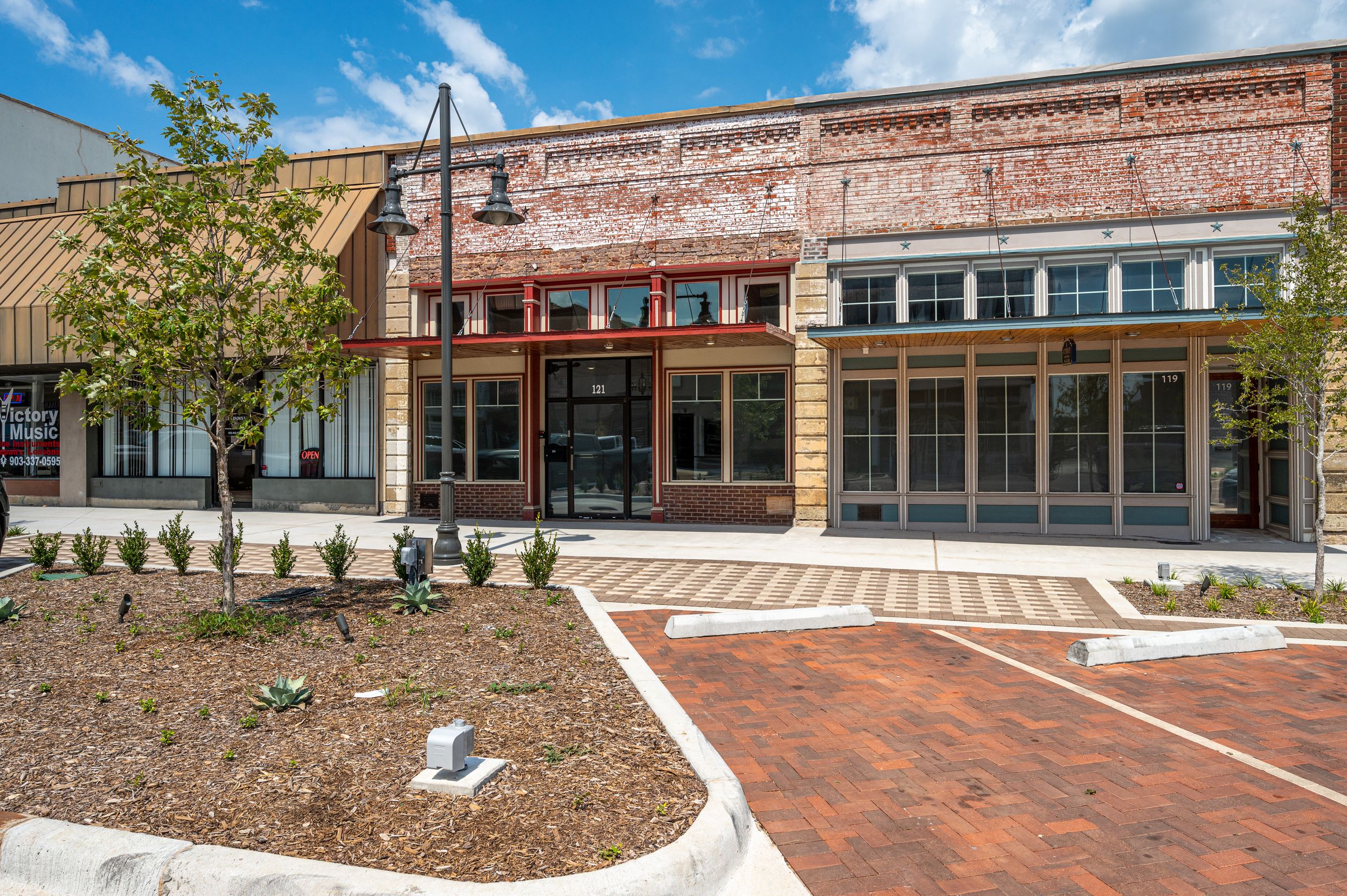 Renovated historic brick storefront with new landscaping and decorative brick paver courtyard.