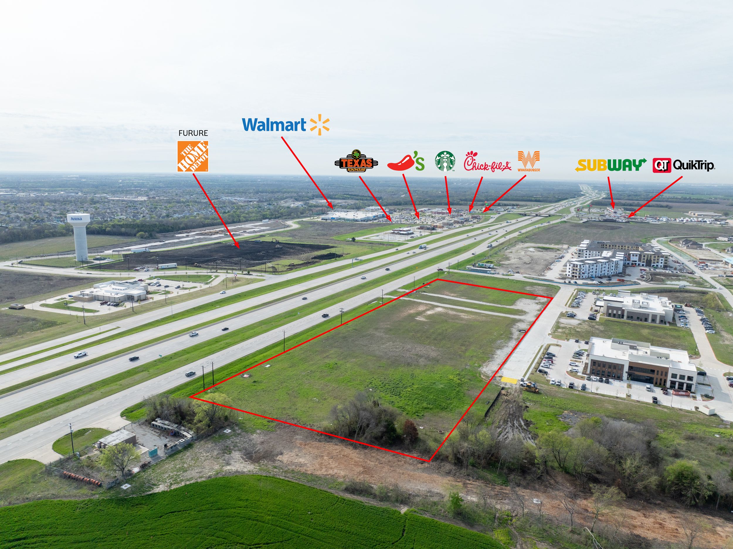 Aerial view of commercial development along highway showing Walmart and other retail stores with labeled businesses.