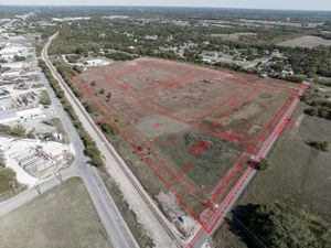 Aerial photograph showing large undeveloped land parcel outlined in red boundary markers.