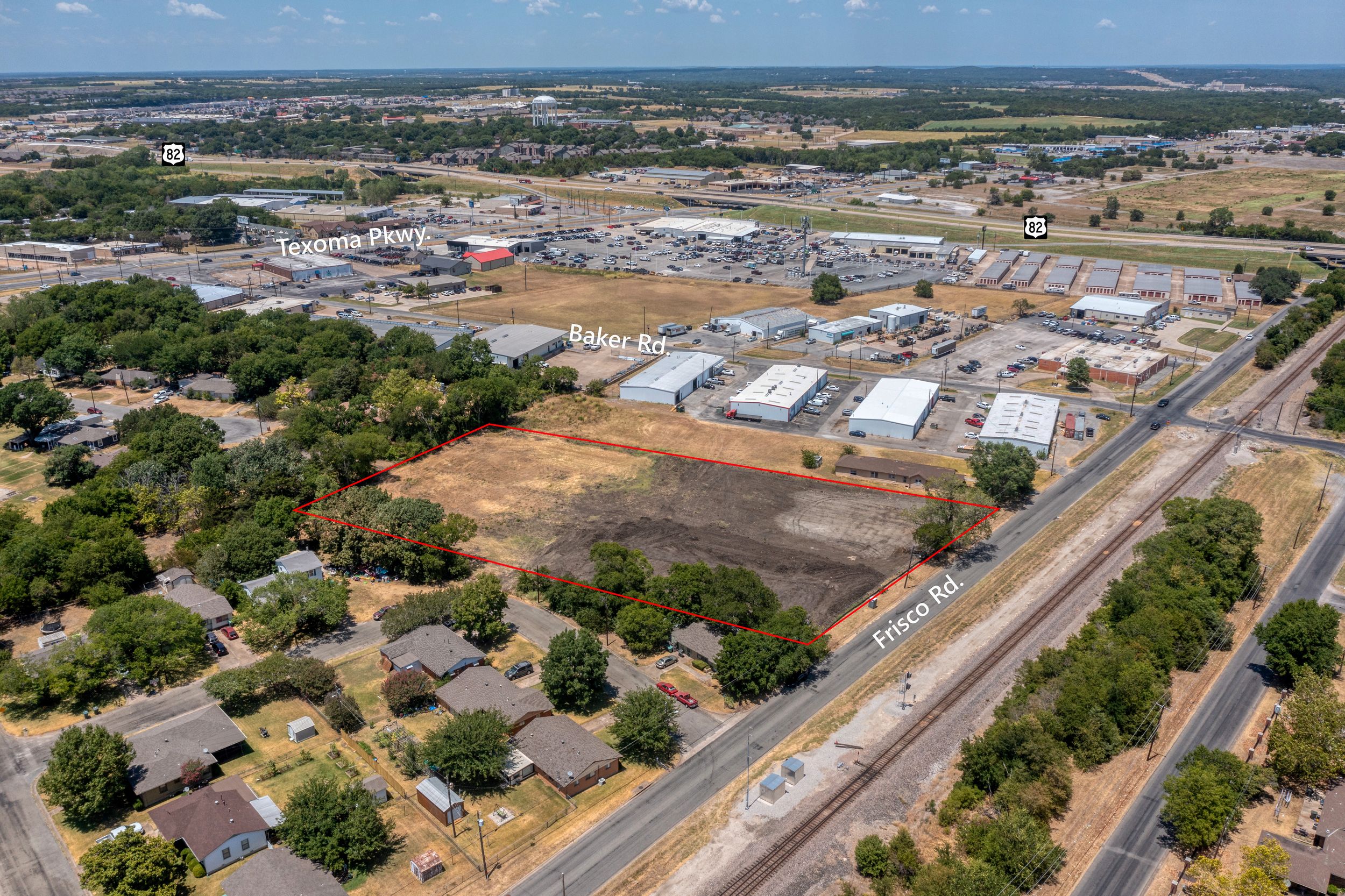 Aerial view of commercial and industrial development with warehouses and residential areas in the background.