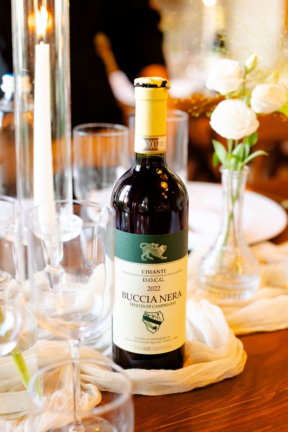 Bottle of Chianti Buccia Nera wine displayed on an elegant table setting with glassware.