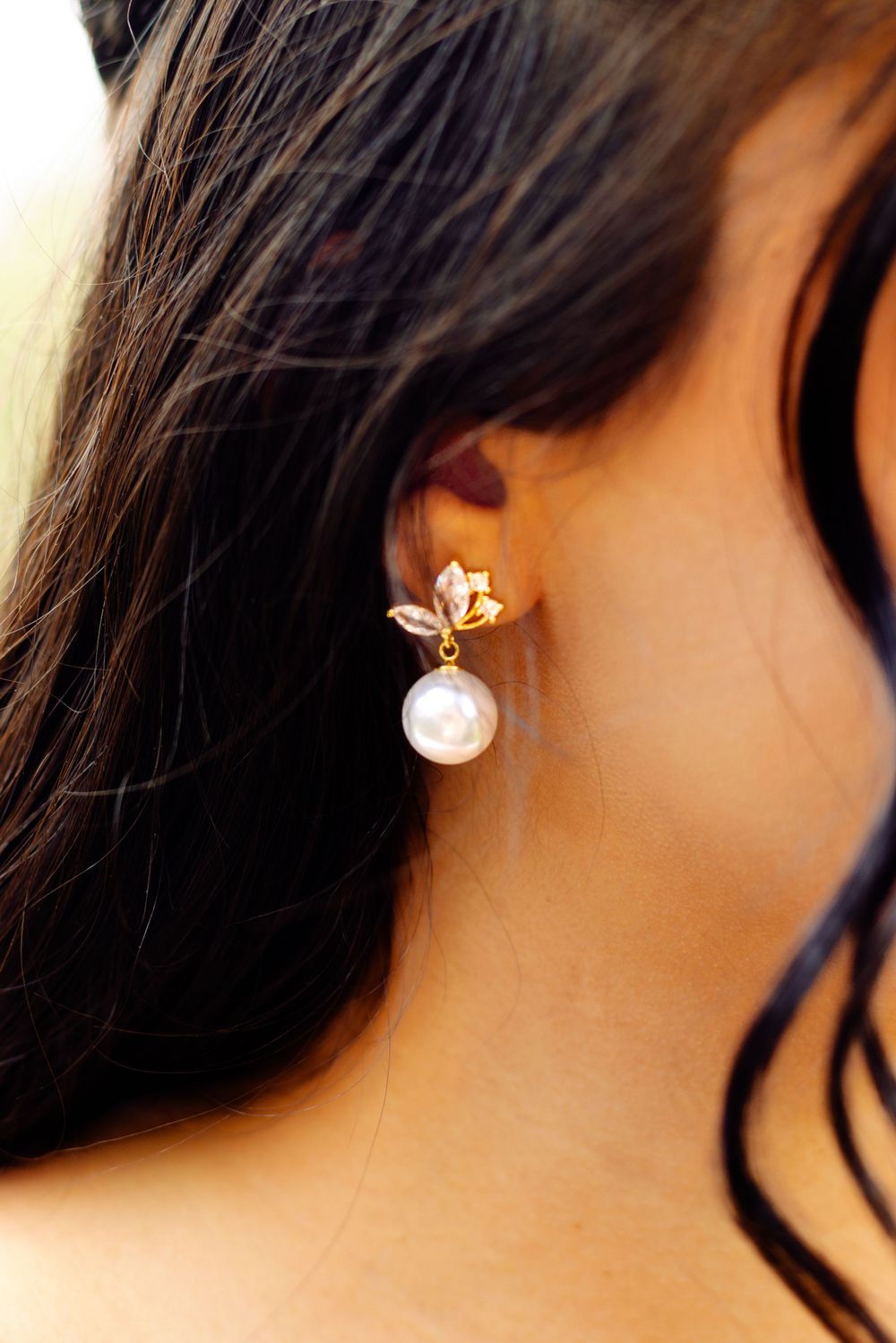 Pearl and crystal bridal earrings shown in close-up detail.