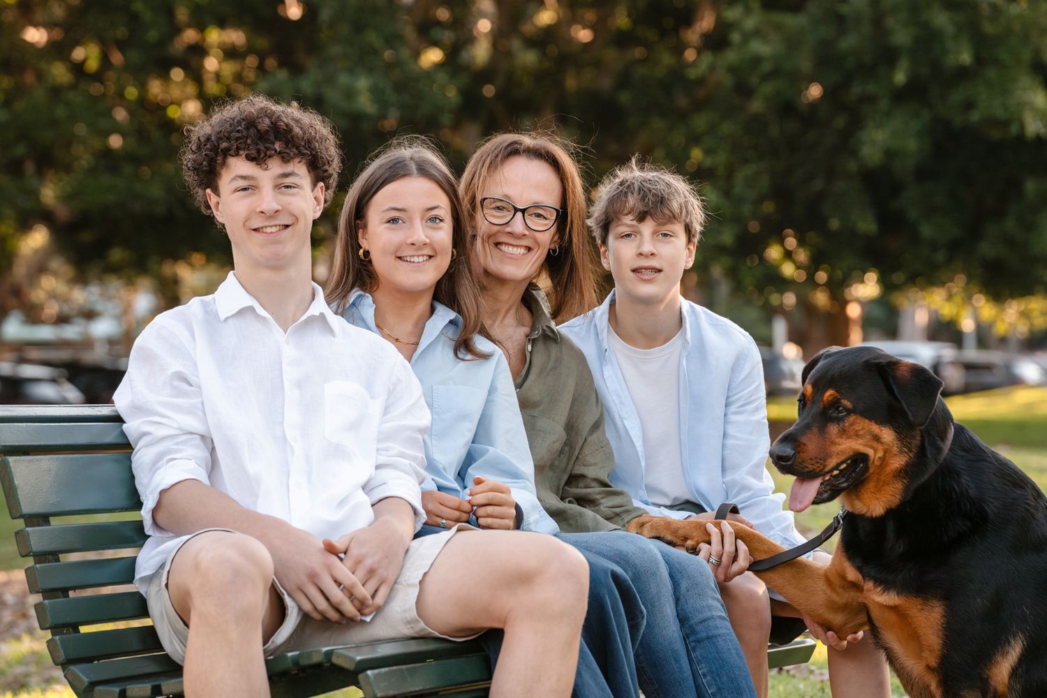 mom and her teenage children sitting on a bench in Mosman with their beautiful dog photoshoot in Mosman