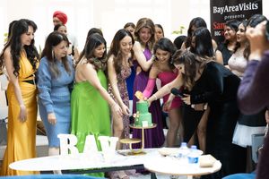 A group gathers around a table with refreshments at a Bay Area Visits event.